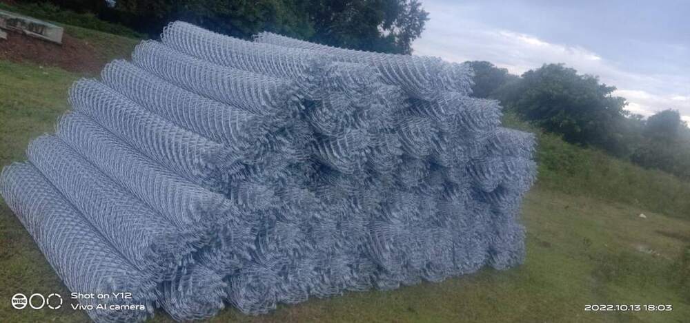 GI chain link mesh rolls stacked at site